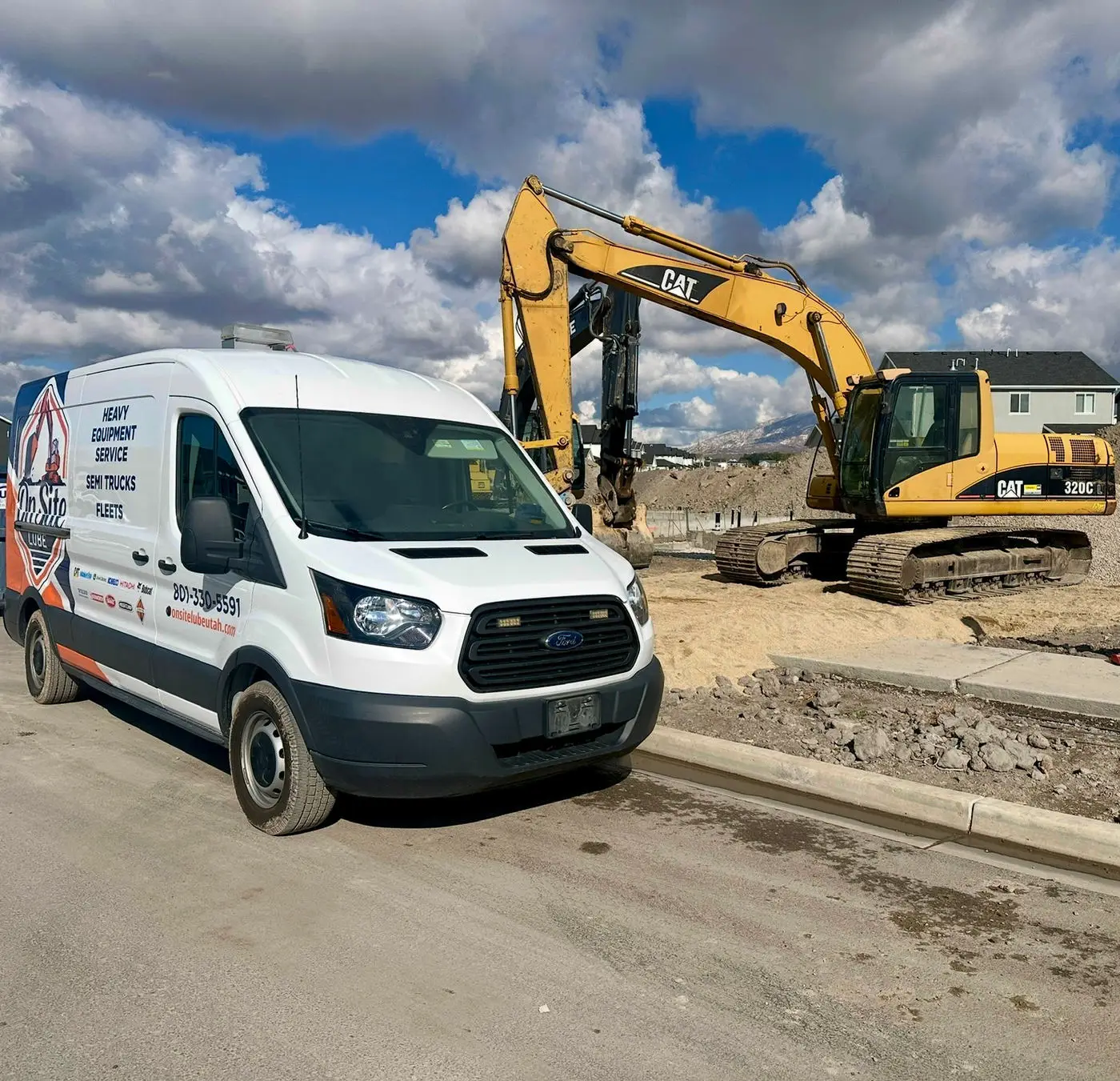 On Site Lube service van parked beside a Cat 320C excavator on a jobsite