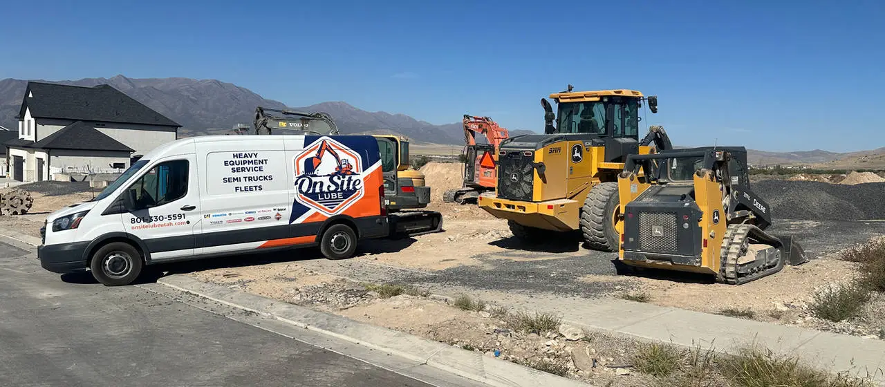 On Site Lube hose repair van on a jobsite beside a John Deere loader and a track loader